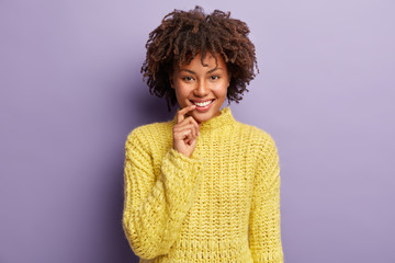 Headshot of glad attractive female looks at camera, poses for making photo, smiles broadly, keeps...