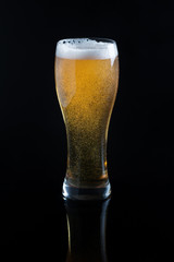 Draft beer in glass on black background