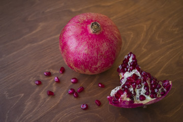 Ripe pomegranate on a wooden table background.