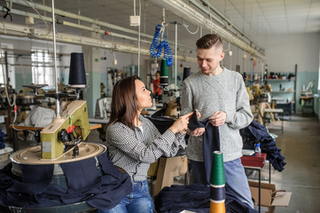 close up photo of a young man and a woman analyzing the work at the linking machine for knitting in textile industry