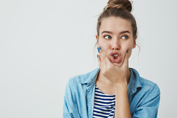 Studio shot funny charismatic european attractive young woman brunette hairbun, looking aside...