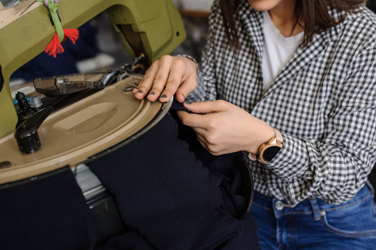 close up photo of a young woman working with linking machine for knitting in textile industry