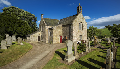 Fototapeta premium A view of the graveyard and church building in Aberlemno in Angus, Scotland.