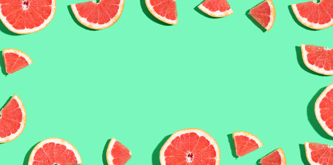 Halved fresh grapefruits on bright color background