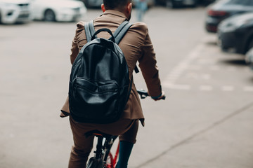Young businessman in a suit riding bicycle