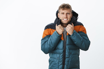 Jeez freezing cold. Portrait of intense trembling handsome european blond man clenching teeth...