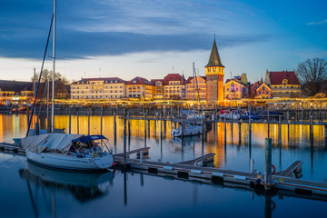 Fototapeta na wymiar Hafenweihnacht, Weihnachtsmarkt, Christkindlsmarkt, romantischer Blick in den Hafen mit glatter Wasserfläche, Booten; warmes Licht mit Spiegelungen am Wasser; D, Bayern, Bodensee, Lindau