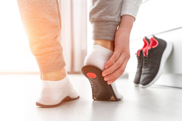 Sports woman fitting orthopedic insoles. Treatment and prevention of flat feet and foot orthopedic...