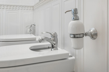 toilet and detail of a corner shower bidet with soap and shampoo dispensers on wall mount shower...
