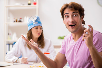 Young handsome man visiting young female doctor otolaryngologist