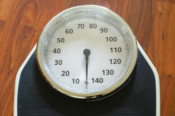 Close-up of a Weight scale on a wooden floor