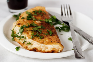 A photo of an omelette with parsley. White background