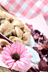 Close-up of gingerbreads, romantic pink flower and a checkered towel in background