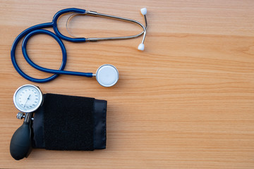 stethoscope and sphygmomanometer on wooden texture background