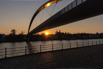 Fototapeta na wymiar Hoge brug by sunset (high bridge = English translation) A pedestrian bridge in downtown Maastricht a popular crossing by students