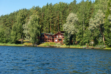 Fototapeta na wymiar Building with a boat dock on the shore of a forest lake