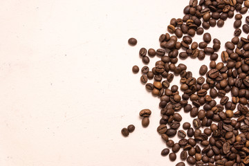 Roasted coffee beans in bulk on a light pink background. dark cofee roasted grain flavor aroma cafe, natural coffe shop background, top view from above, copy space