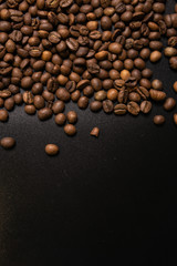 Roasted coffee beans in bulk on a black background. dark cofee roasted grain flavor aroma cafe, natural coffe shop background, top view from above, copy space