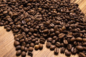 Roasted coffee beans in bulk on a wooden background