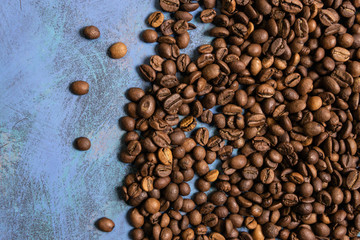Roasted coffee beans in bulk on a blue background. dark cofee roasted grain flavor aroma cafe,...