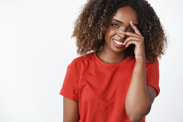 Girl hearing compliment blushing and looking with sincere loving gaze at camera holding hand on...