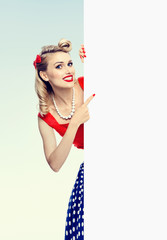 woman in pin-up style dress, showing blank signboard
