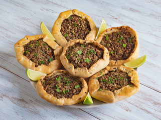 Arabic meat sfiha over a wooden table. 