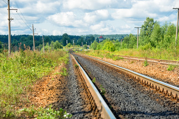 Fototapeta na wymiar Railway track goes beyond the horizon through the forest