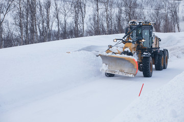 Snow plow truck clearing icy road after winter snowstorm blizzard for vehicle access Snow blower...