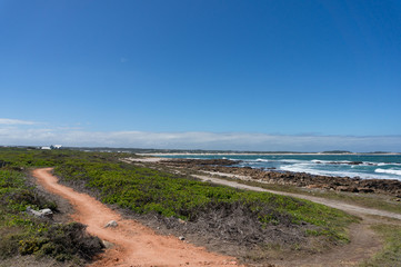 Seascape with dirt trails, tracks and beach in the distance