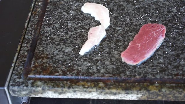 Meat cooking on hot stone grill