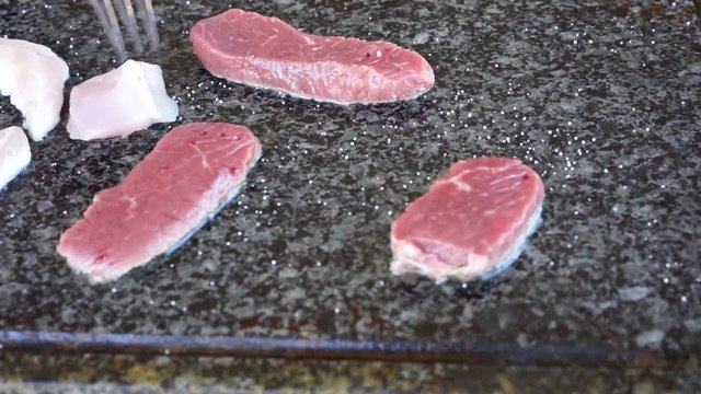 Meat cooking on hot stone grill