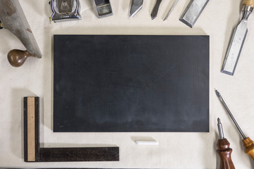 blackboard for chalk on a workbench and carpentry tools