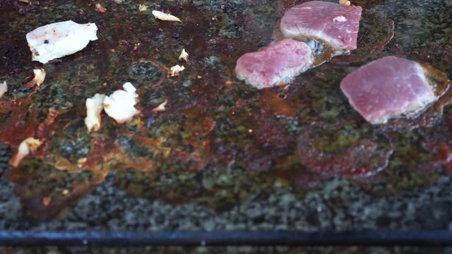 Meat cooking on hot stone grill