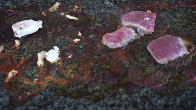 Meat cooking on hot stone grill
