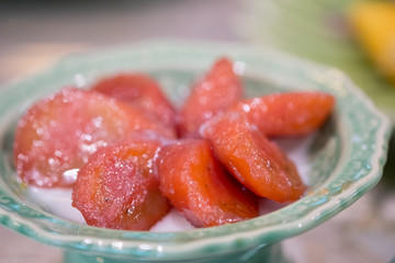 Banana with syrup and coconut milk in green bowl