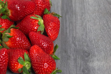 Heap of fresh strawberry on wooden grey table with copy space. Food photography background