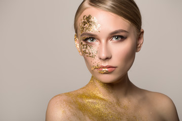 Closeup Of Beautiful Girl With Cosmetic Gold Mask On Soft Smooth Skin.