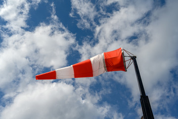 Windsock over blue and cloudy sky