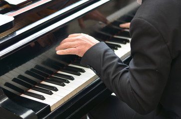 the hands of the musician on the piano