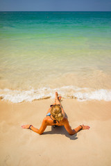Woman enjoying her holidays on the tropical beach i