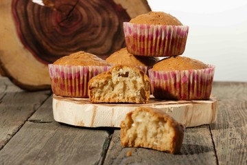 homemade muffins with coconut chips on a wooden stand