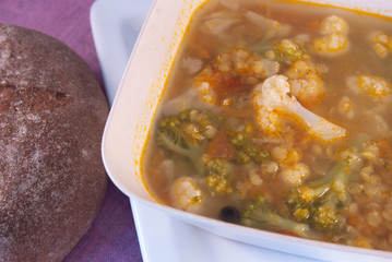 Soup with red lentils, broccoli, cauliflower and rye bread on the table