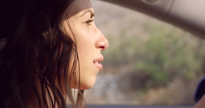 Attractive woman driving car - looks into mirror - close up on face