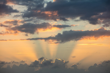 The setting sun lights the sky and drifting clouds over the Caribbean Sea.