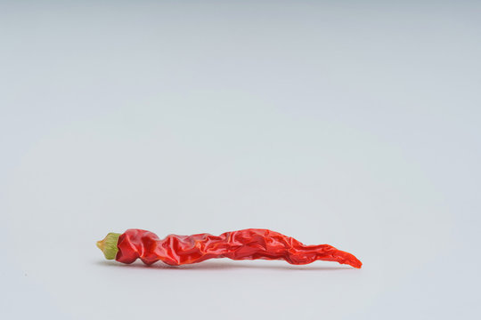 Red hot chili peppers on a white background. Dry, shriveled red pepper. Dehydration of vegetables.