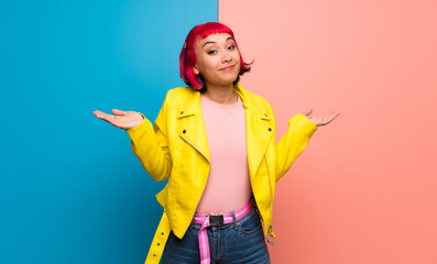 Young woman with yellow jacket making unimportant gesture while lifting the shoulders