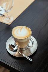 Top view of Hot Cappucino with blur green background. White froth on coffee and milk with copy space.