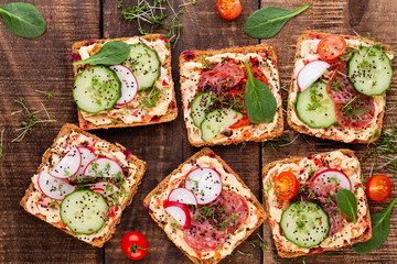 Sandwiches with cream cheese, vegetables and salami.