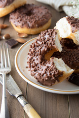 Chocolate donuts breakfast or dessert, wooden table. Close up glazed donuts. Sweet food. Pastry.